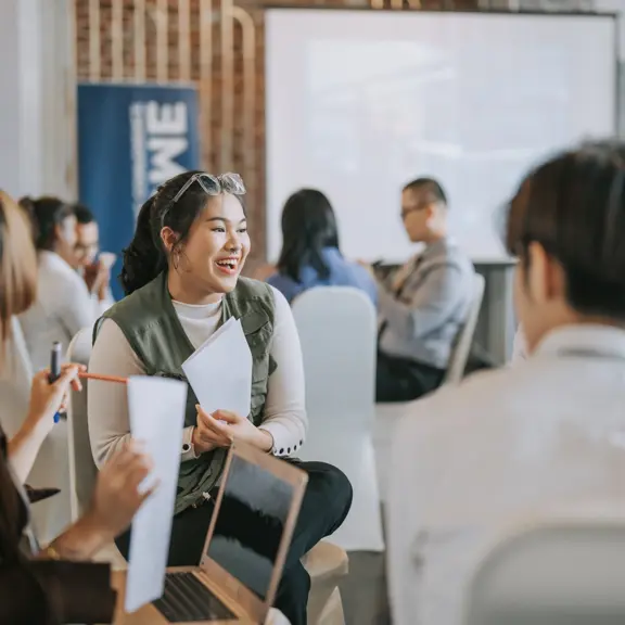 Vrouwelijke student die samen werkt met andere studenten