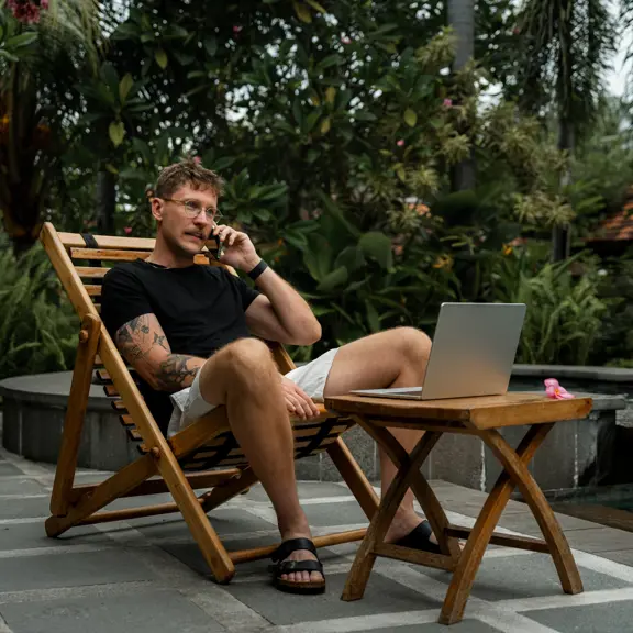 Expat met laptop aan het werk in de buitenlucht op een terras